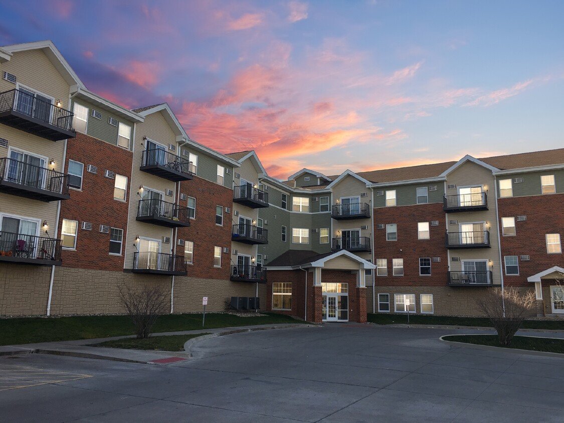 Apartment complex with a sunset sky in the background.